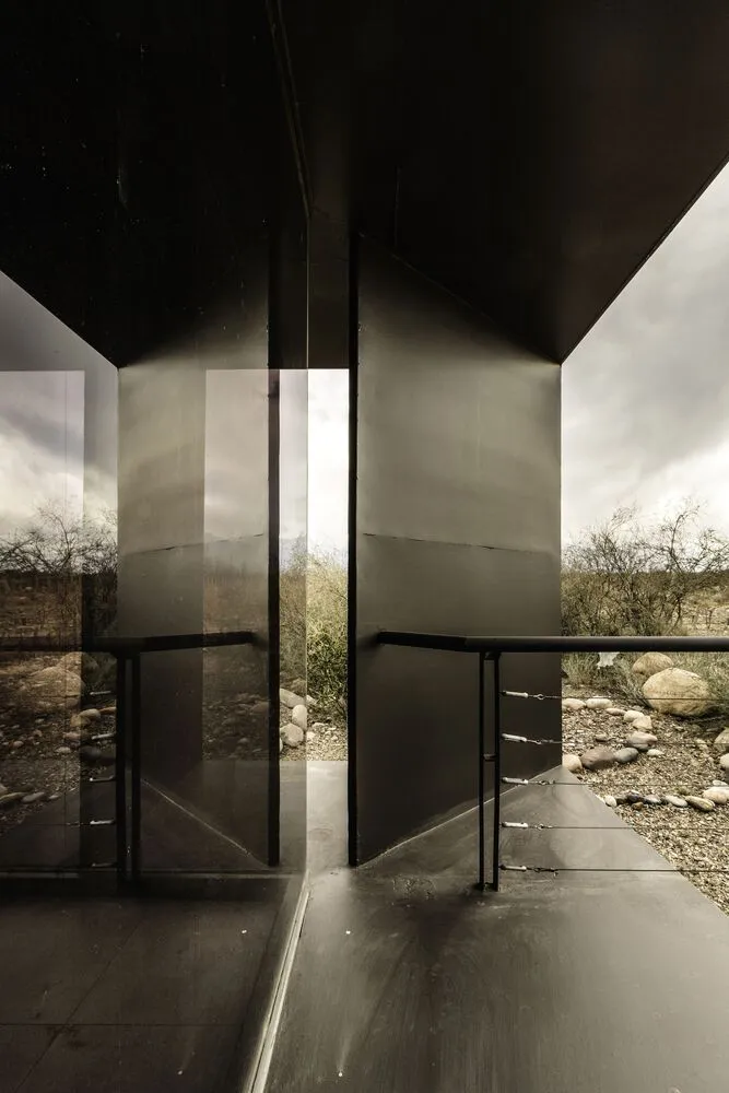 Modern exterior of a building featuring glass walls and a metal roof.
