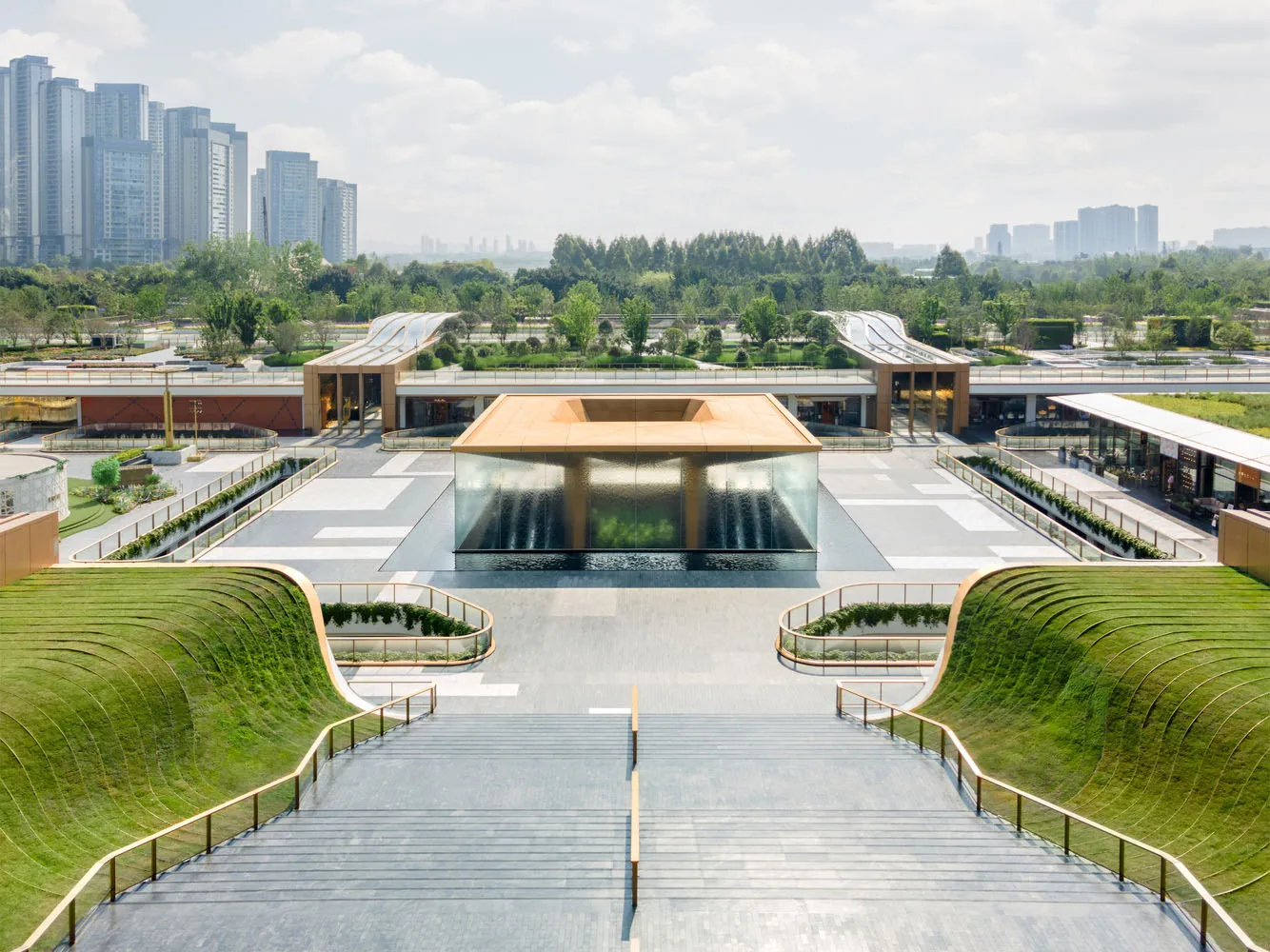 Modern public space featuring glass, steel, and concrete elements.