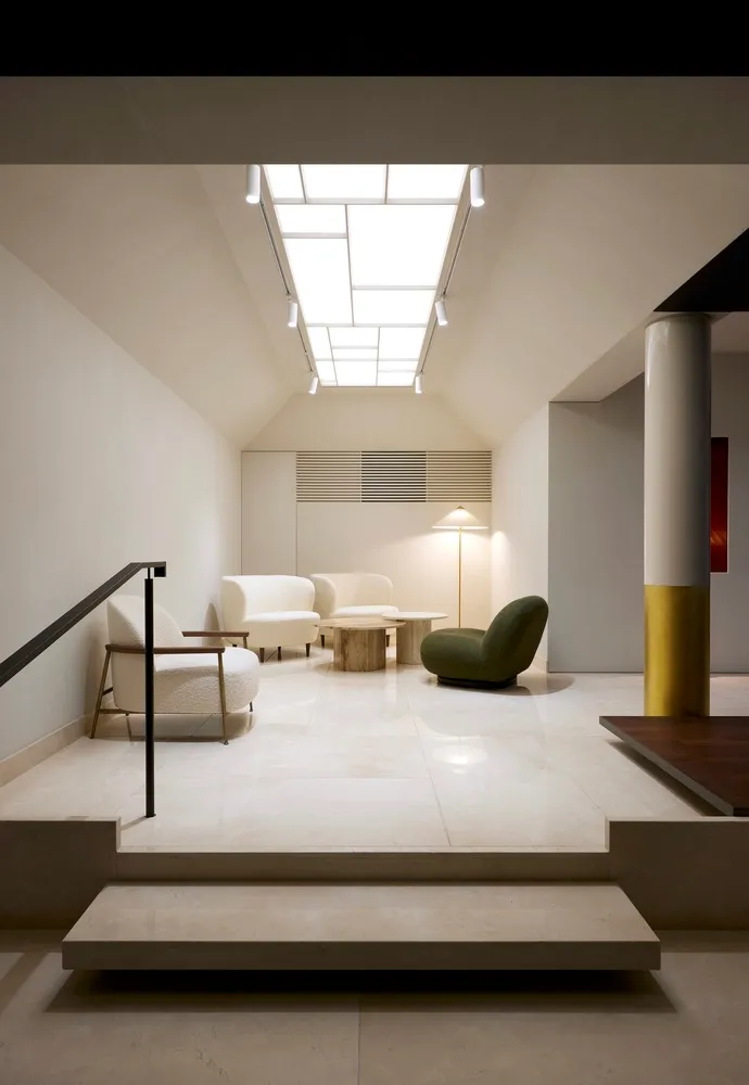 Modern living room with white marble flooring and minimalist furniture arrangement.