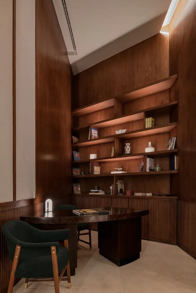 A modern wooden home library featuring a desk with built-in shelves.