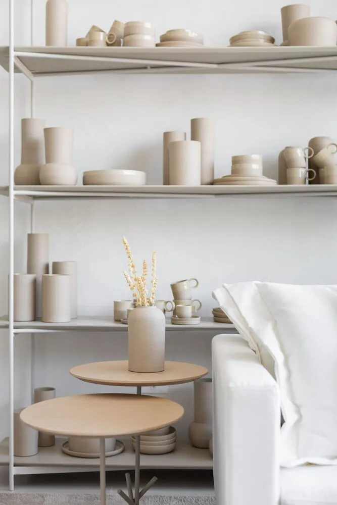 A modern home displaying an extensive ceramic collection, including vases, bowls, cups, and plates.