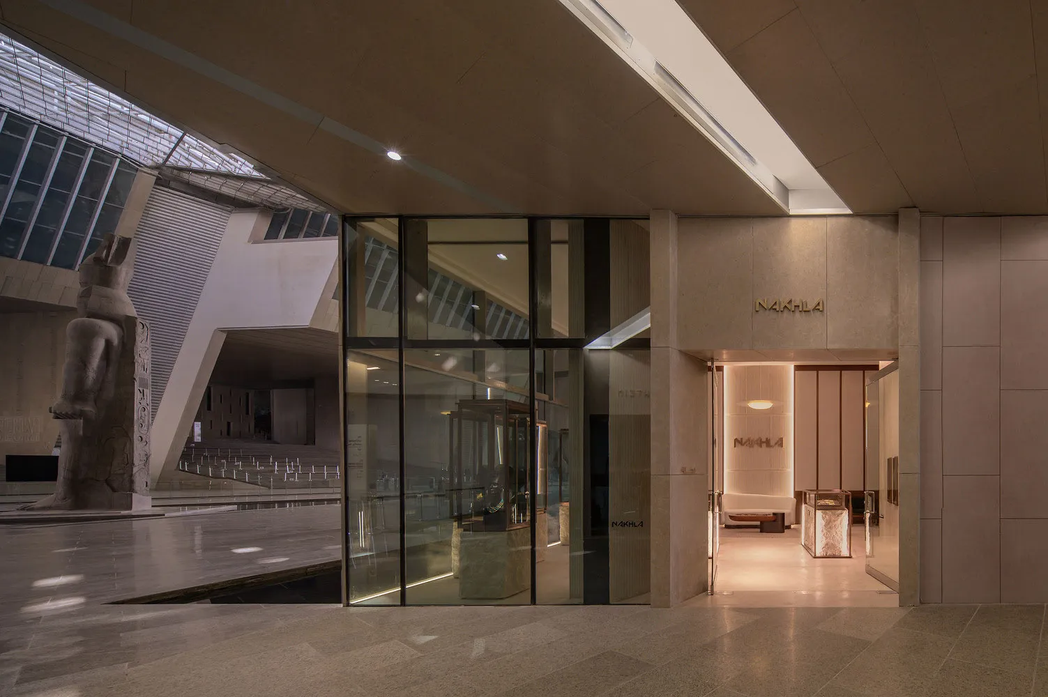 Modern lobby interior with glass walls and concrete flooring.