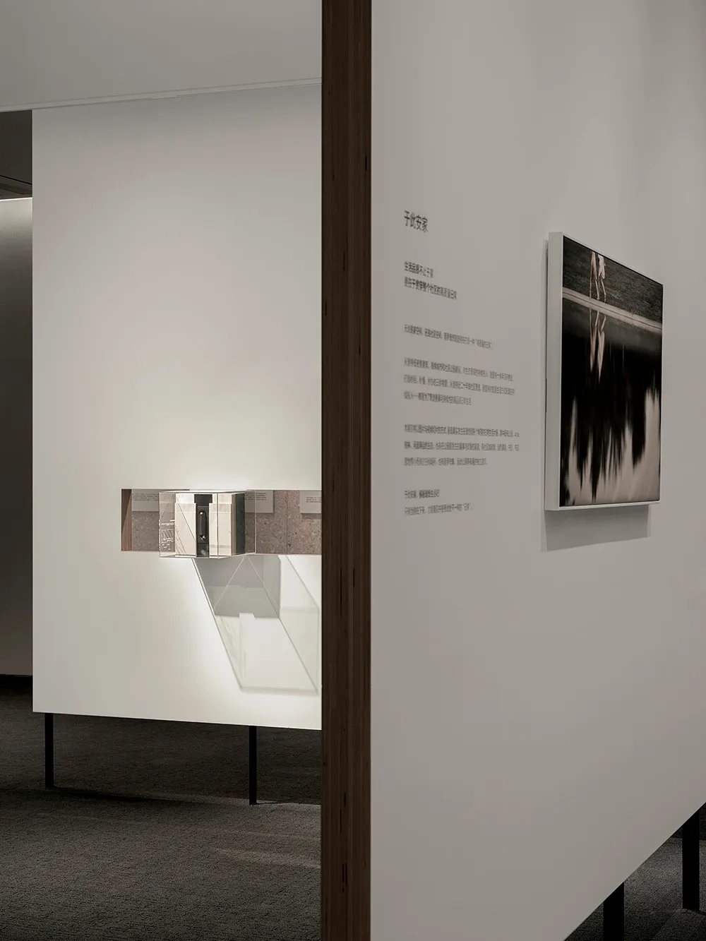 A minimalist installation featuring mixed media elements, including a photo and text.