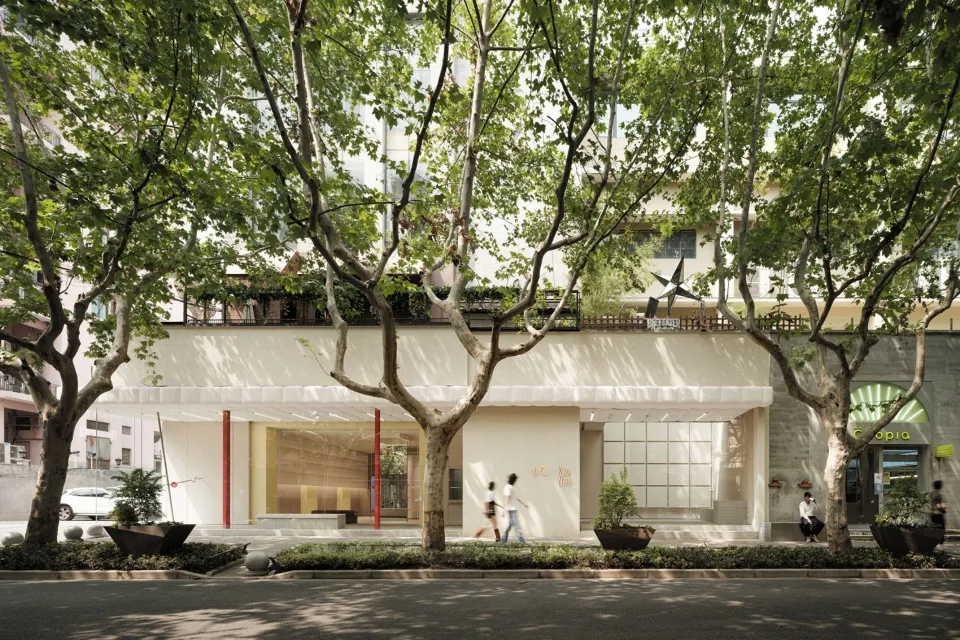 A modern building with concrete, glass, and greenery.