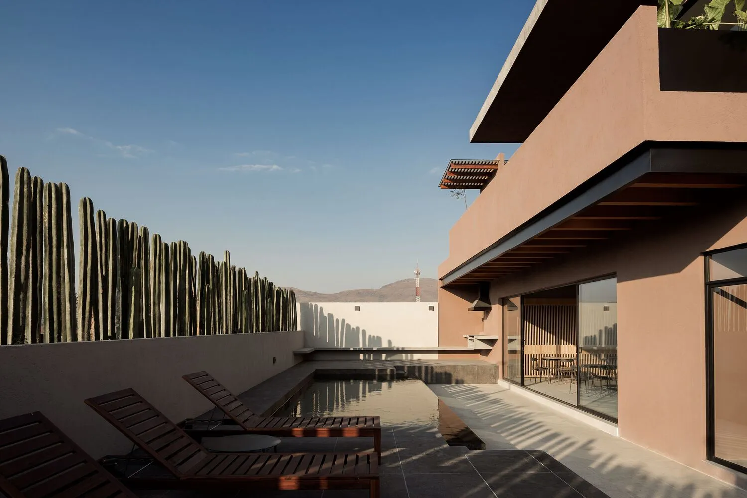 Modern, concrete building interior with a courtyard pool and lounge chairs.