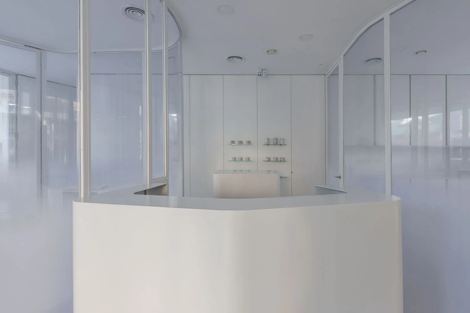A modern reception counter with glass walls and a minimalist design.