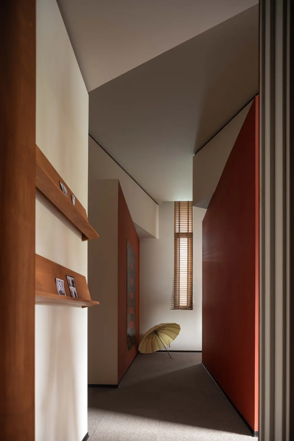 Modern minimalist corridor interior features wooden walls and floors, with a yellow umbrella leaning against the wall.