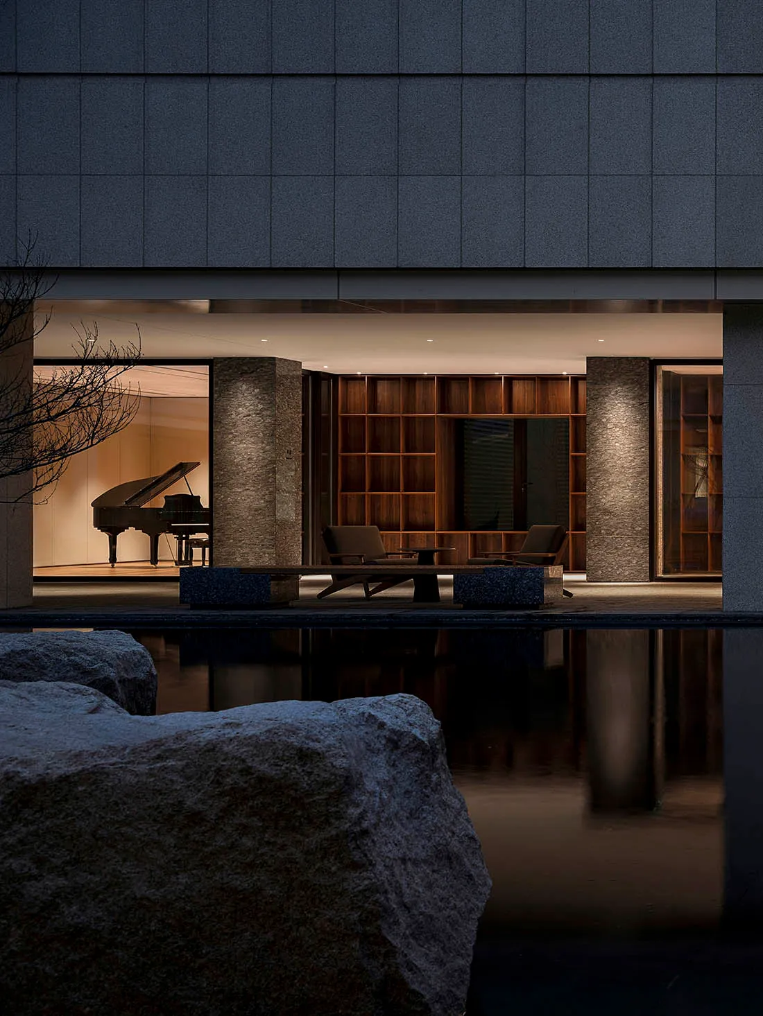 Modern minimalist living room featuring stone, wood, and stainless steel materials.