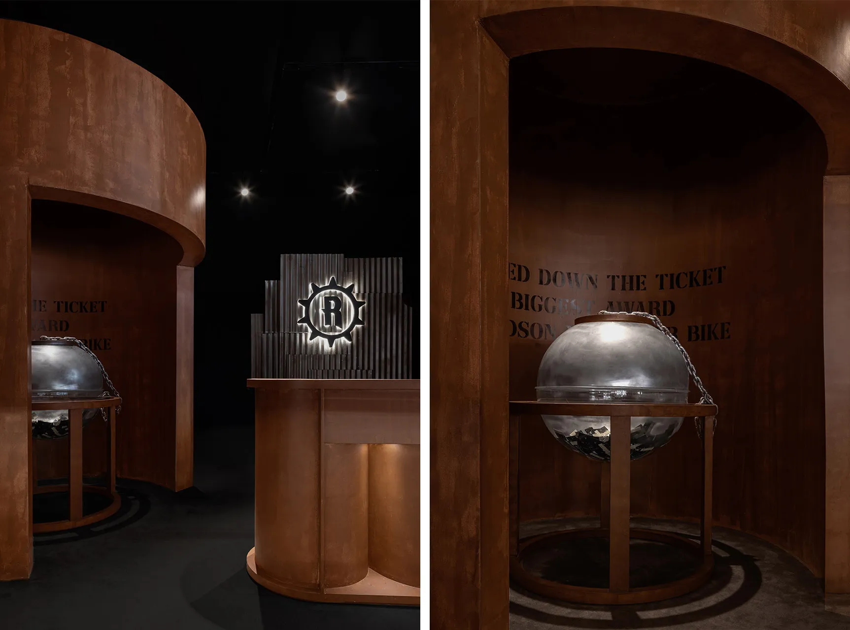 A metal sphere with a textured surface and chain links on a wooden stand in an industrial-themed exhibit environment.