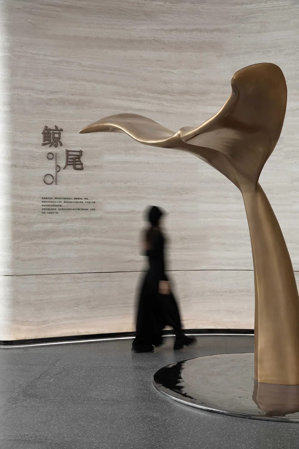 A futuristic, metal sculpture resembling a whale's tail accentuates a modern interior design space.