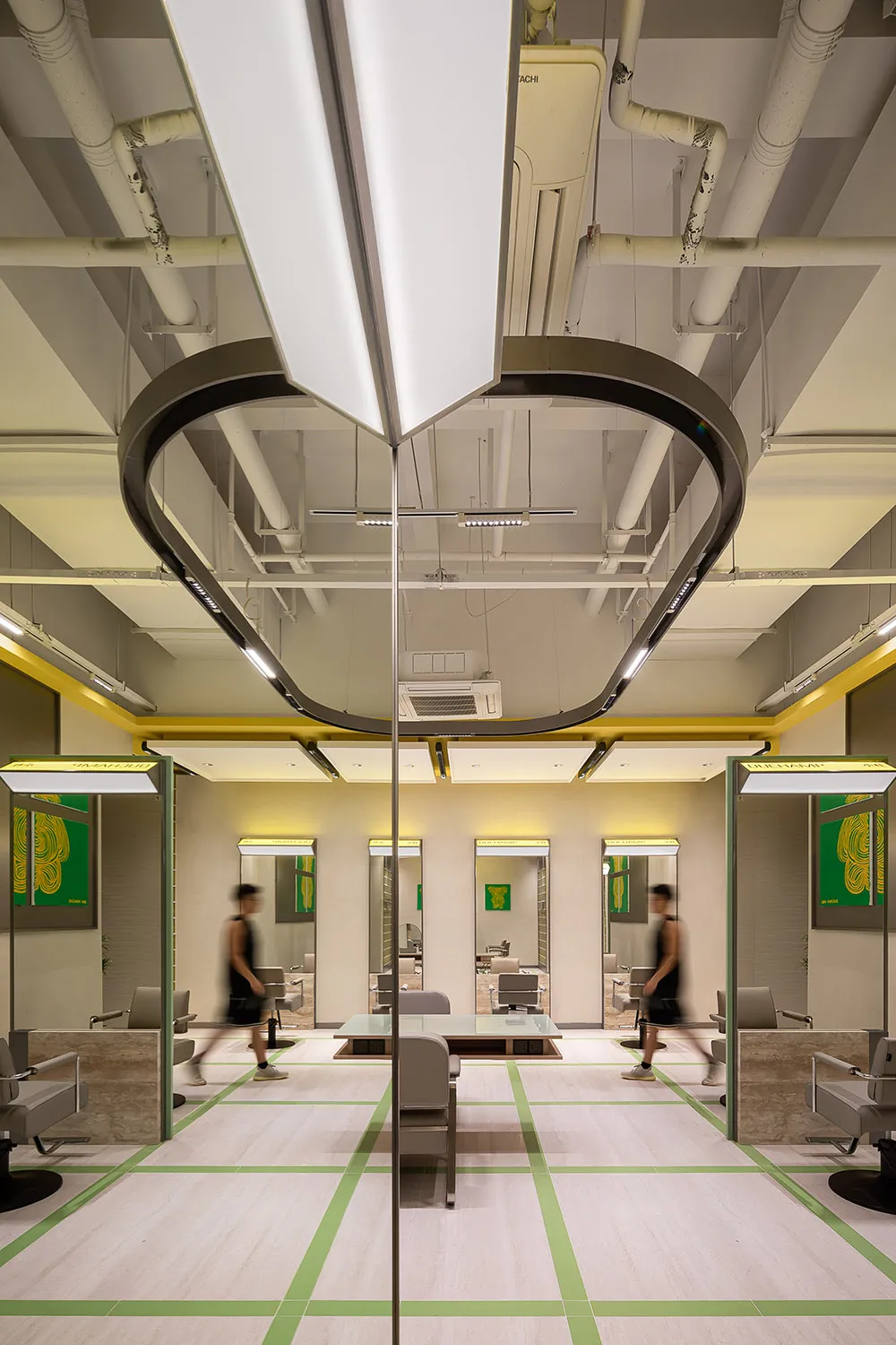 A modern hair salon interior with clean lines, contemporary lighting, and green accents.