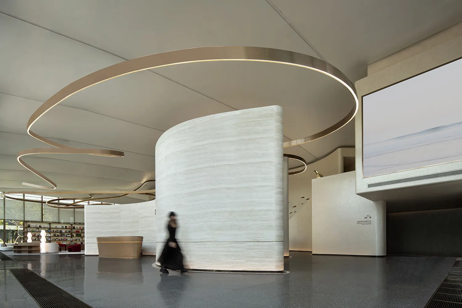A contemporary lobby featuring minimalist design with marble walls and flooring.