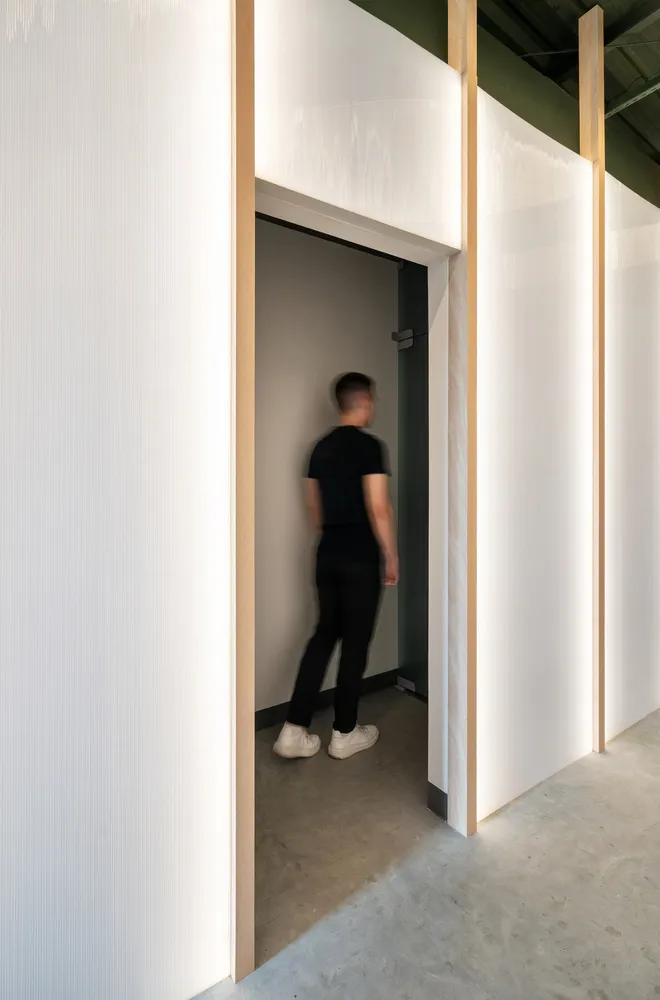 A modern office space featuring white walls clad in sandwich panels