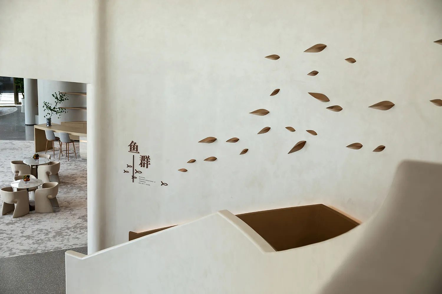 Modern restaurant interior with white concrete walls and a floating staircase.