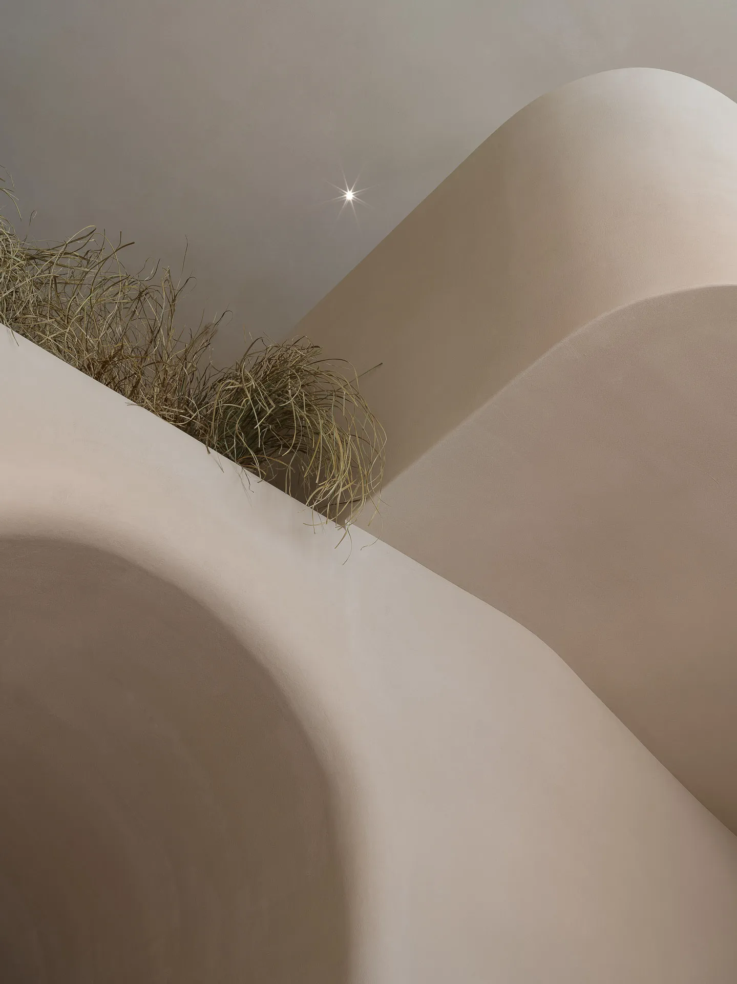 A minimalist interior space with concrete walls and a small grassy area.