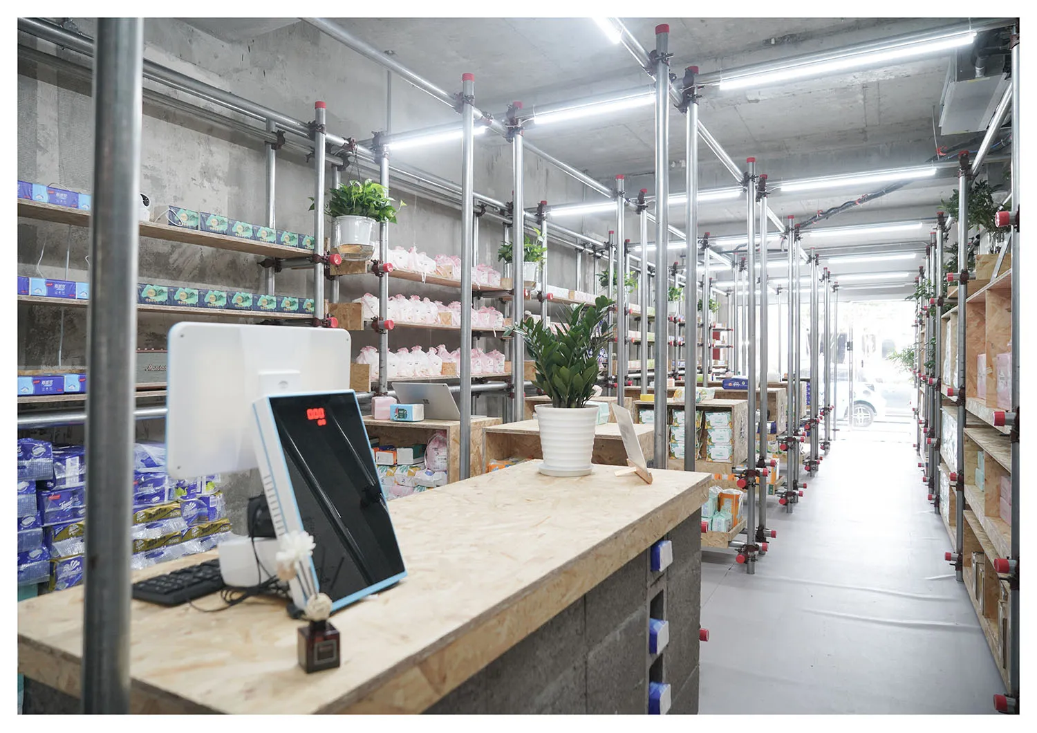 倉庫室內視圖，採用極簡設計，混凝土牆面、金屬橫樑與木製層架。