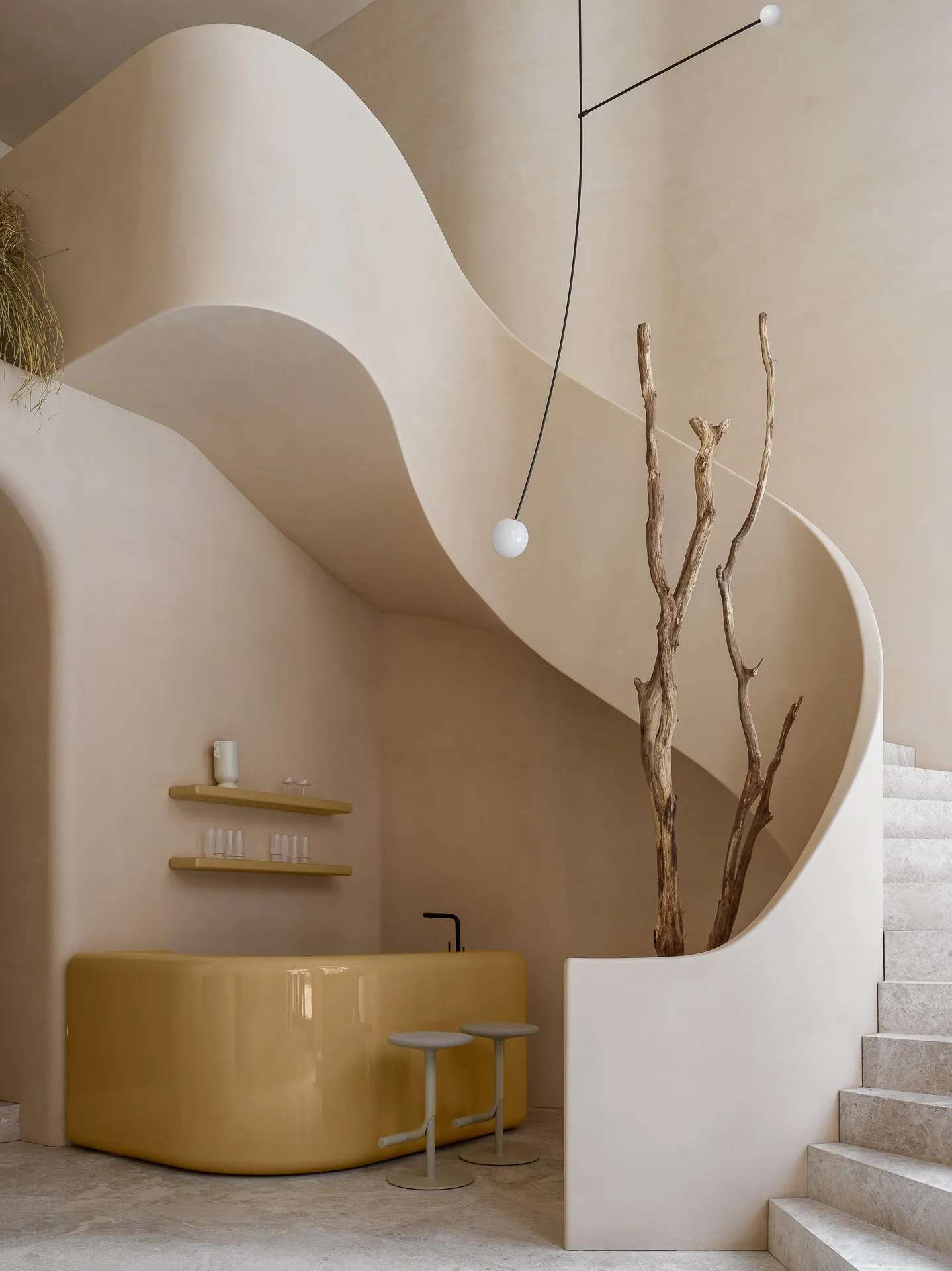 A modern bar area with a concrete flow and organic tree elements.