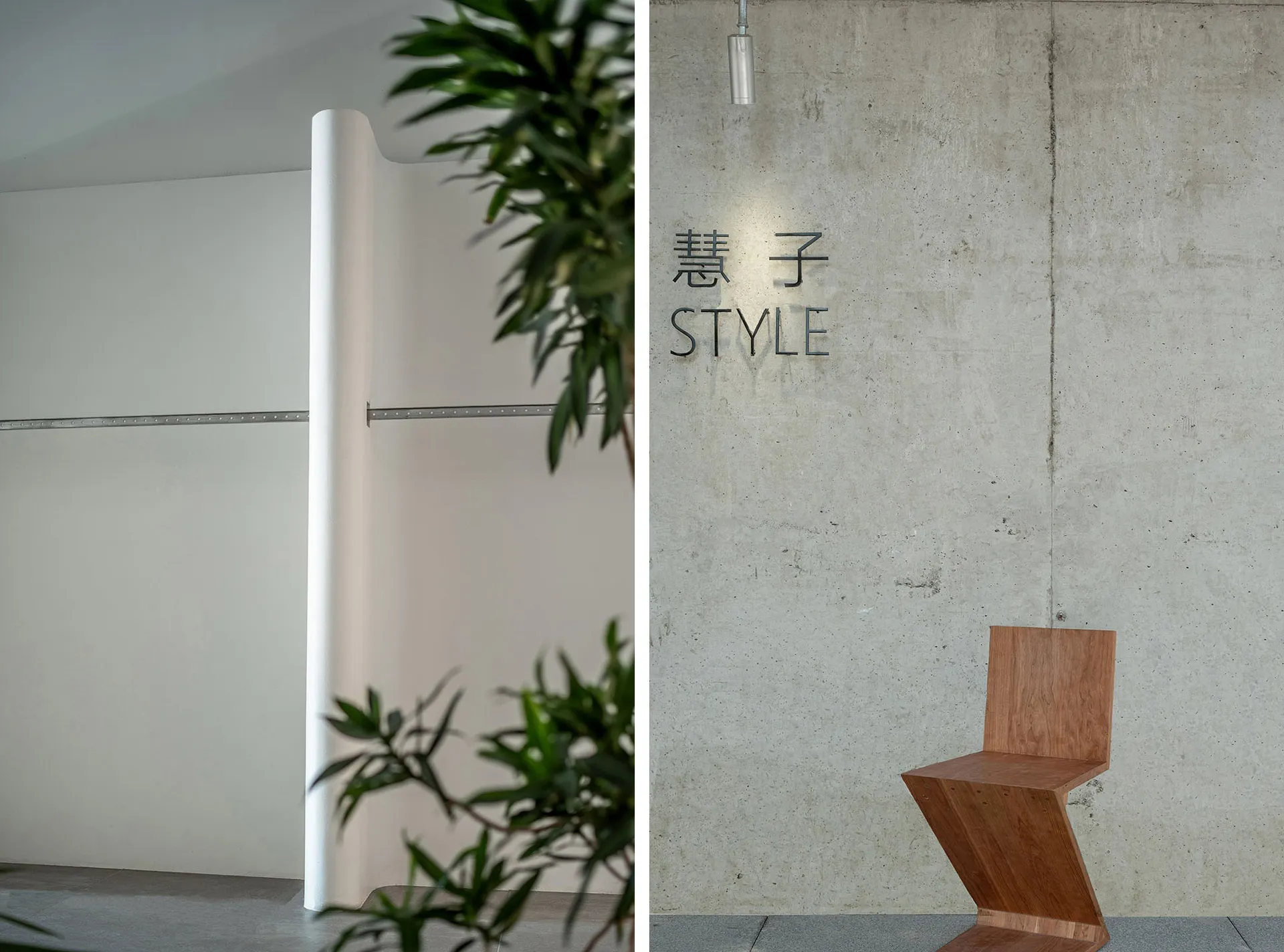 Modern, minimalist space with concrete walls and floor, featuring a unique wooden chair and green foliage.