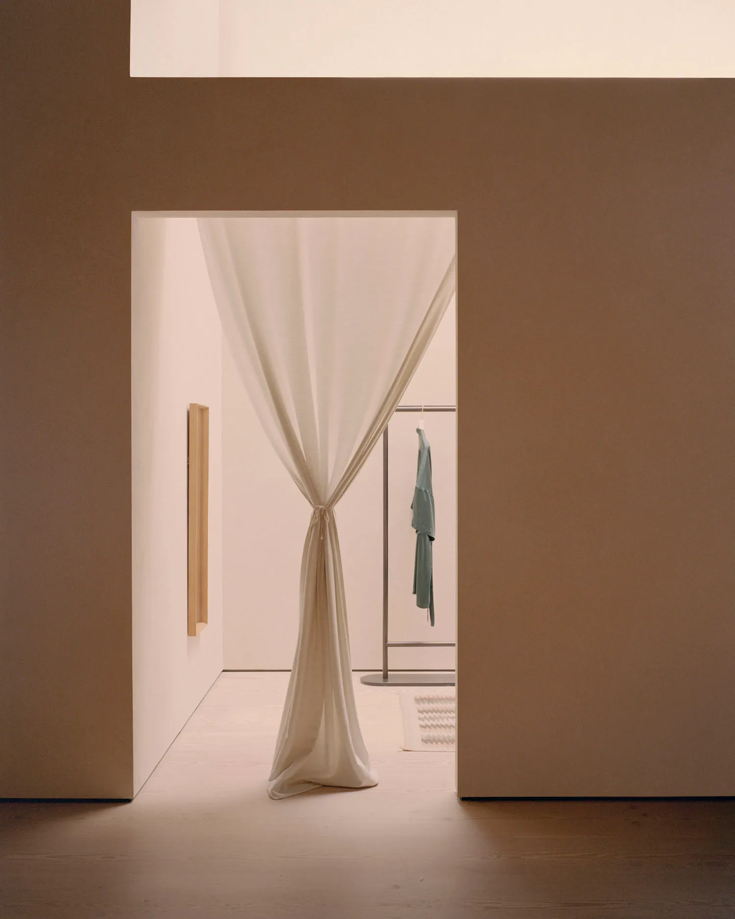 A minimalist clothing store with a white curtain covering the opening.