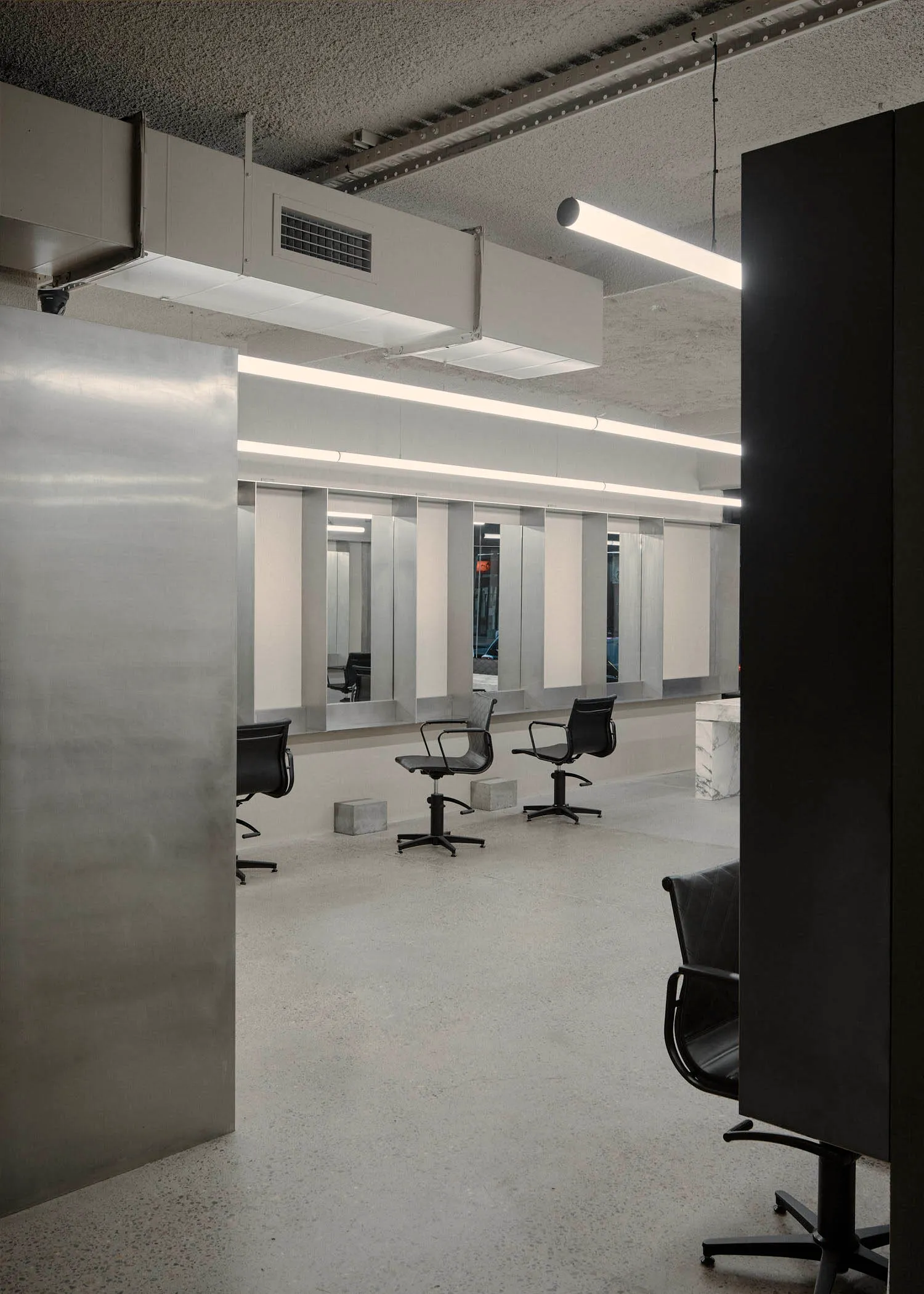 Modern minimalist hair salons with concrete floors and walls.