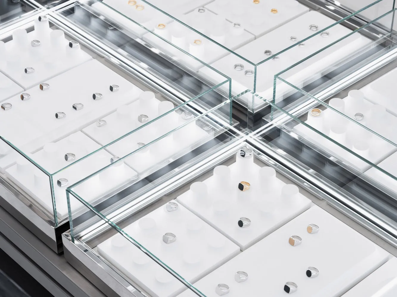 A display of jewelry rings in glass cases.
