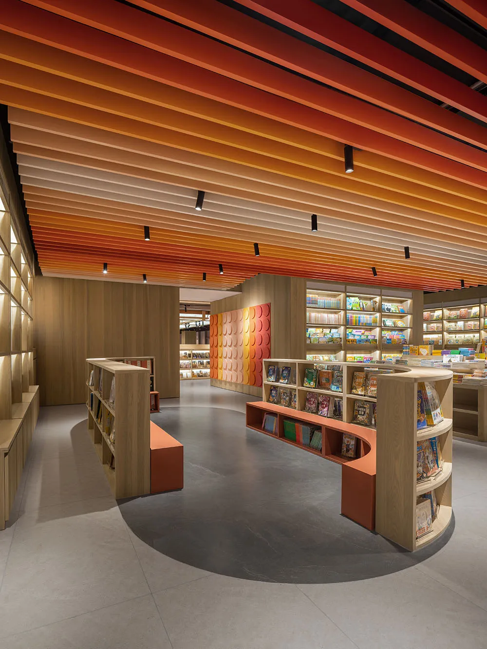 現代簡約書店室內，帶有曲線木質結構與彩色天花板橫樑。