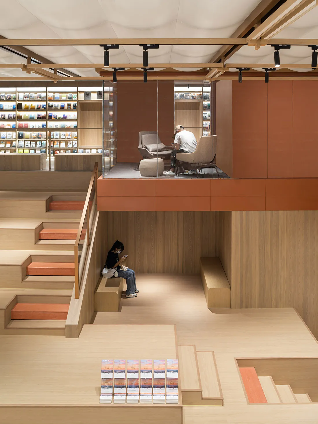 A modern library or bookstore interior with wooden materials and open seating areas.