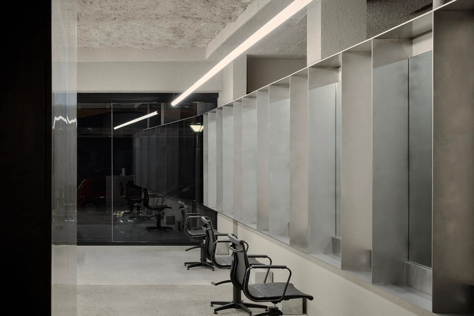 A minimalist office interior featuring industrial-style concrete walls and flooring.