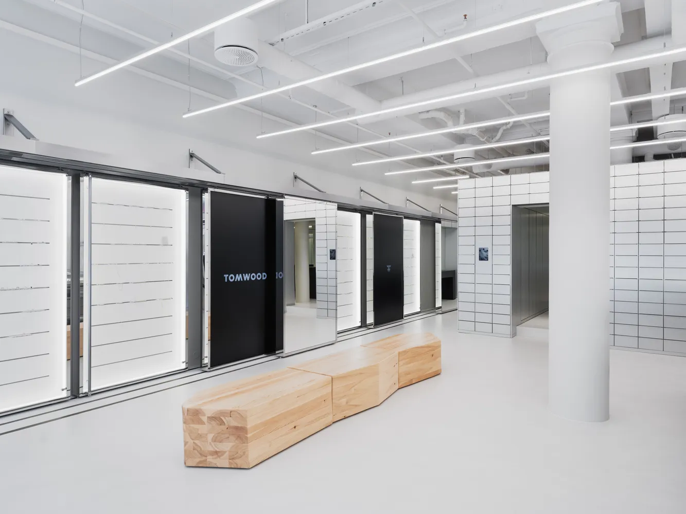 A modern retail shop with a minimalist design featuring wooden elements and white surfaces.