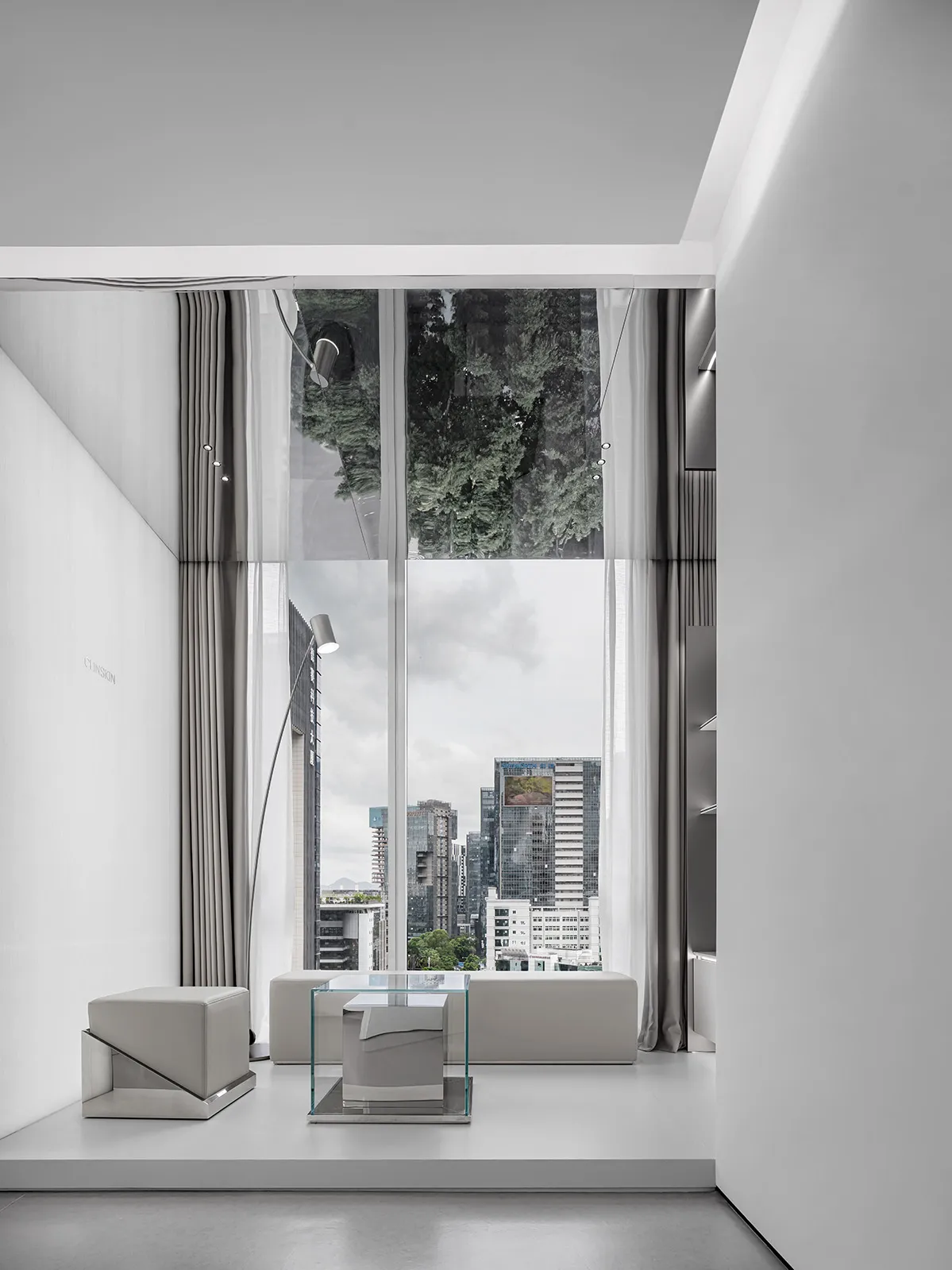 Modern minimalist interior featuring a glass wall with a cityscape view.