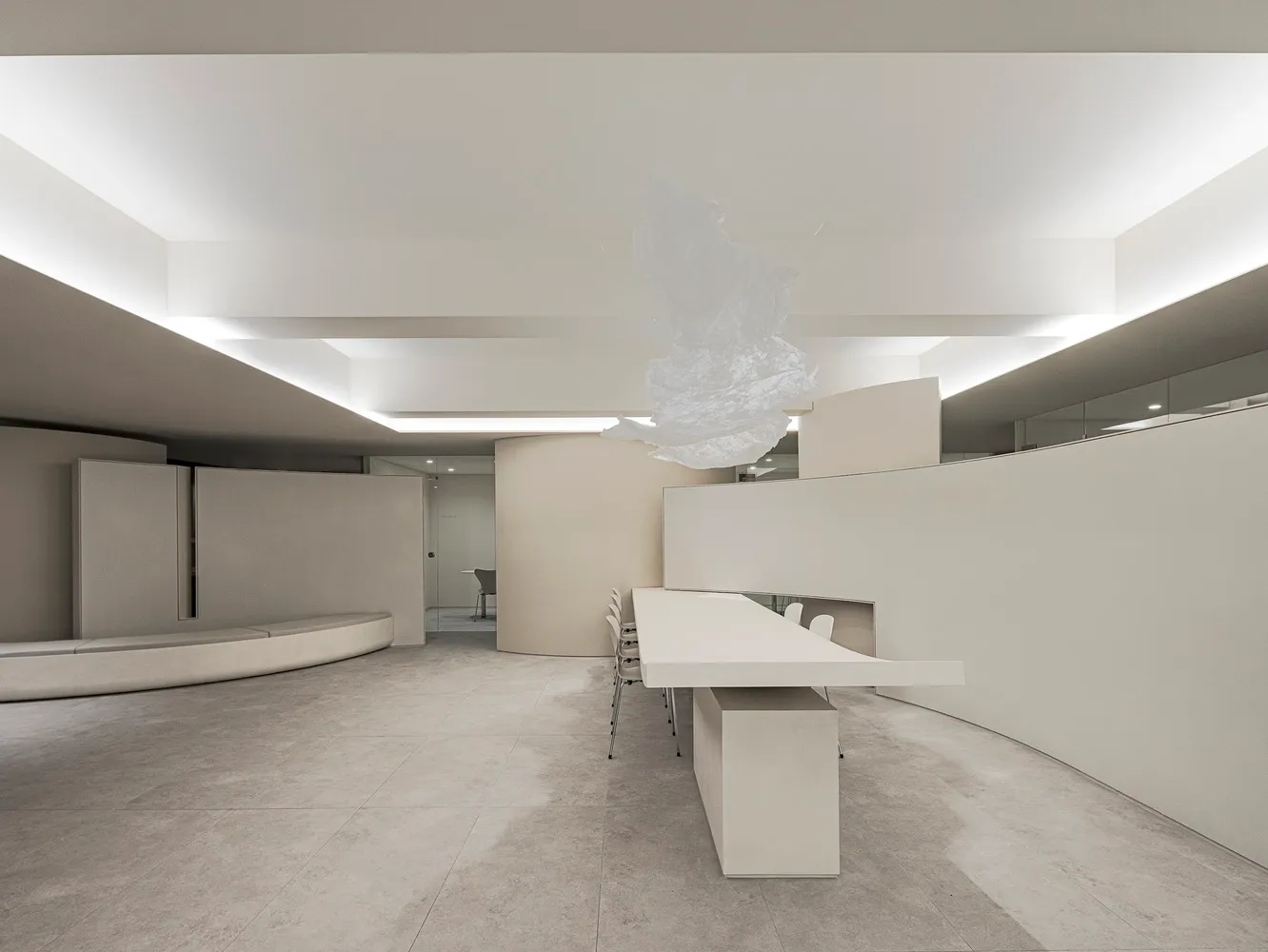 A minimalist office space featuring concrete walls and floors.