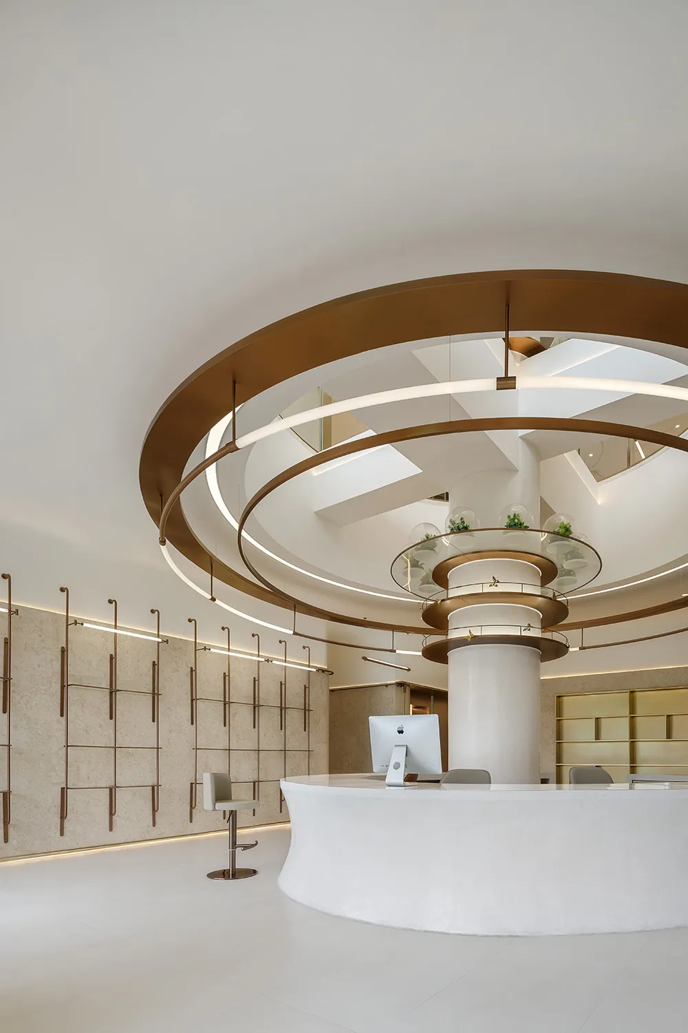 A modern lobby features dreamy white materials with circular elements and a sleek, white reception desk.
