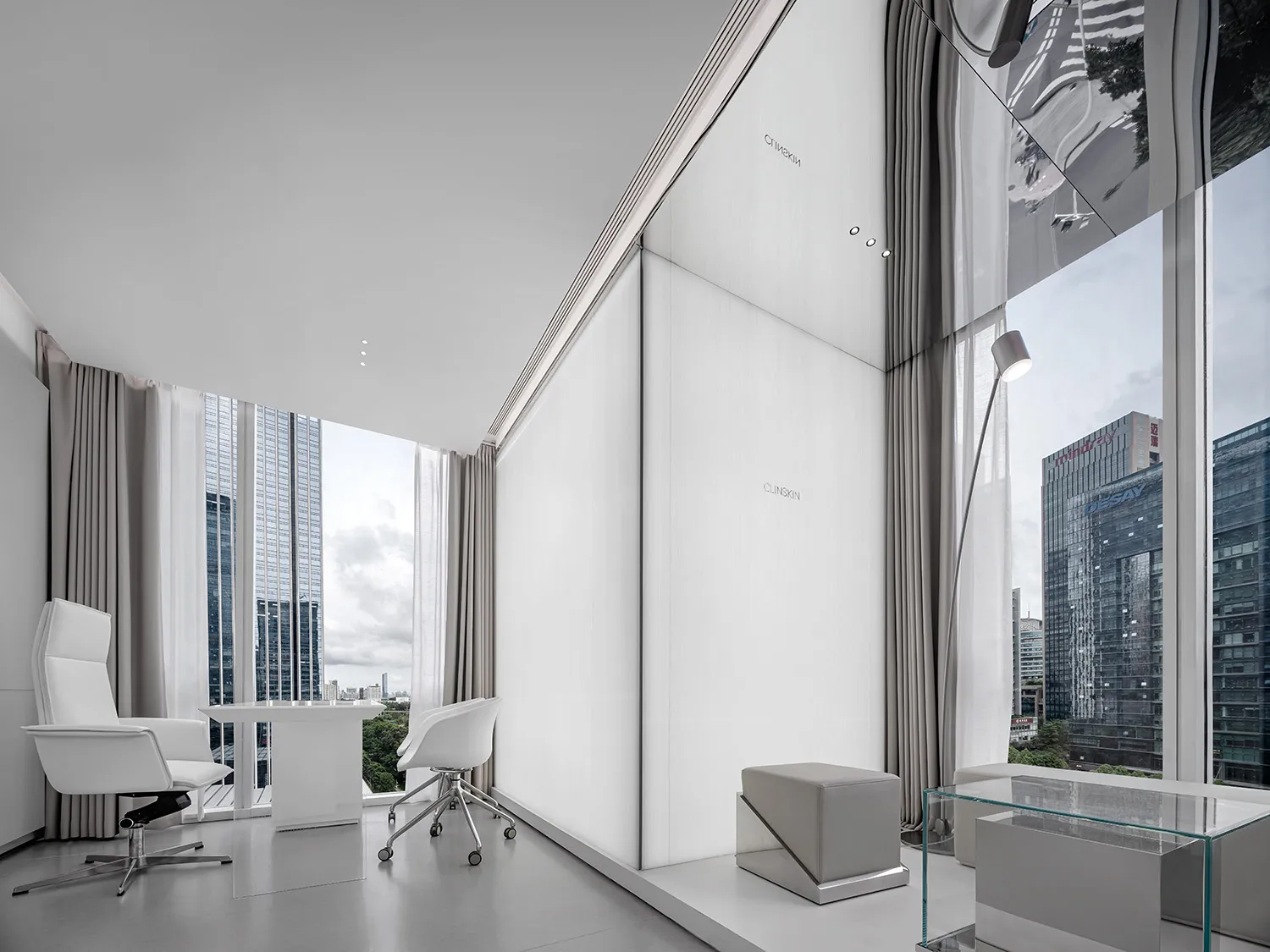 Modern office interior featuring concrete walls and white furniture.