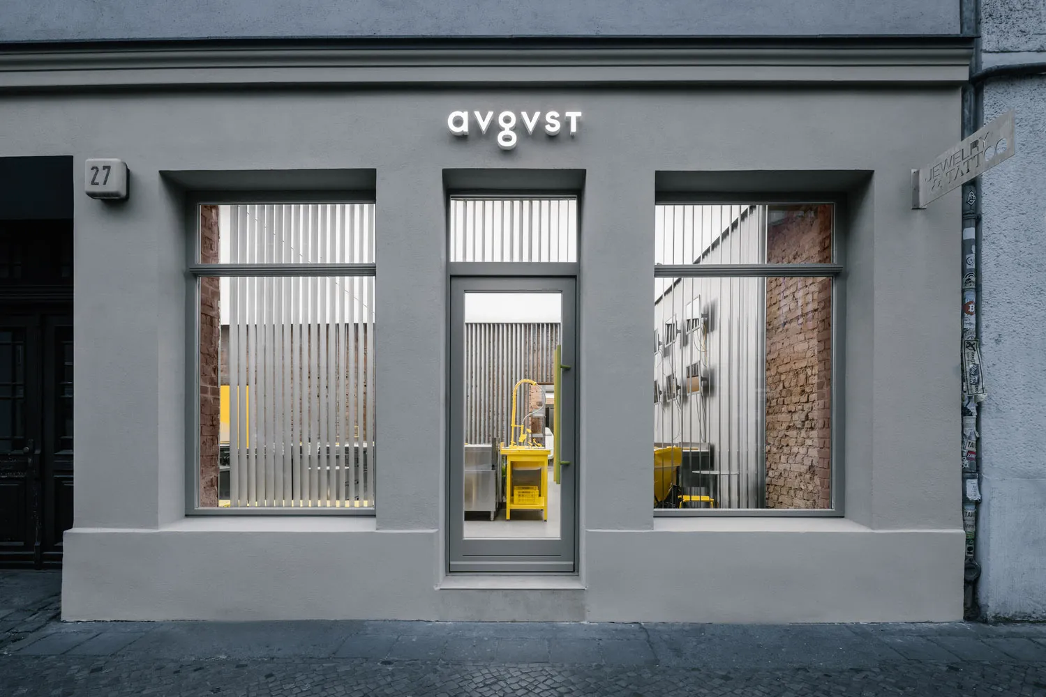 Modern storefront with metal bars and yellow accents