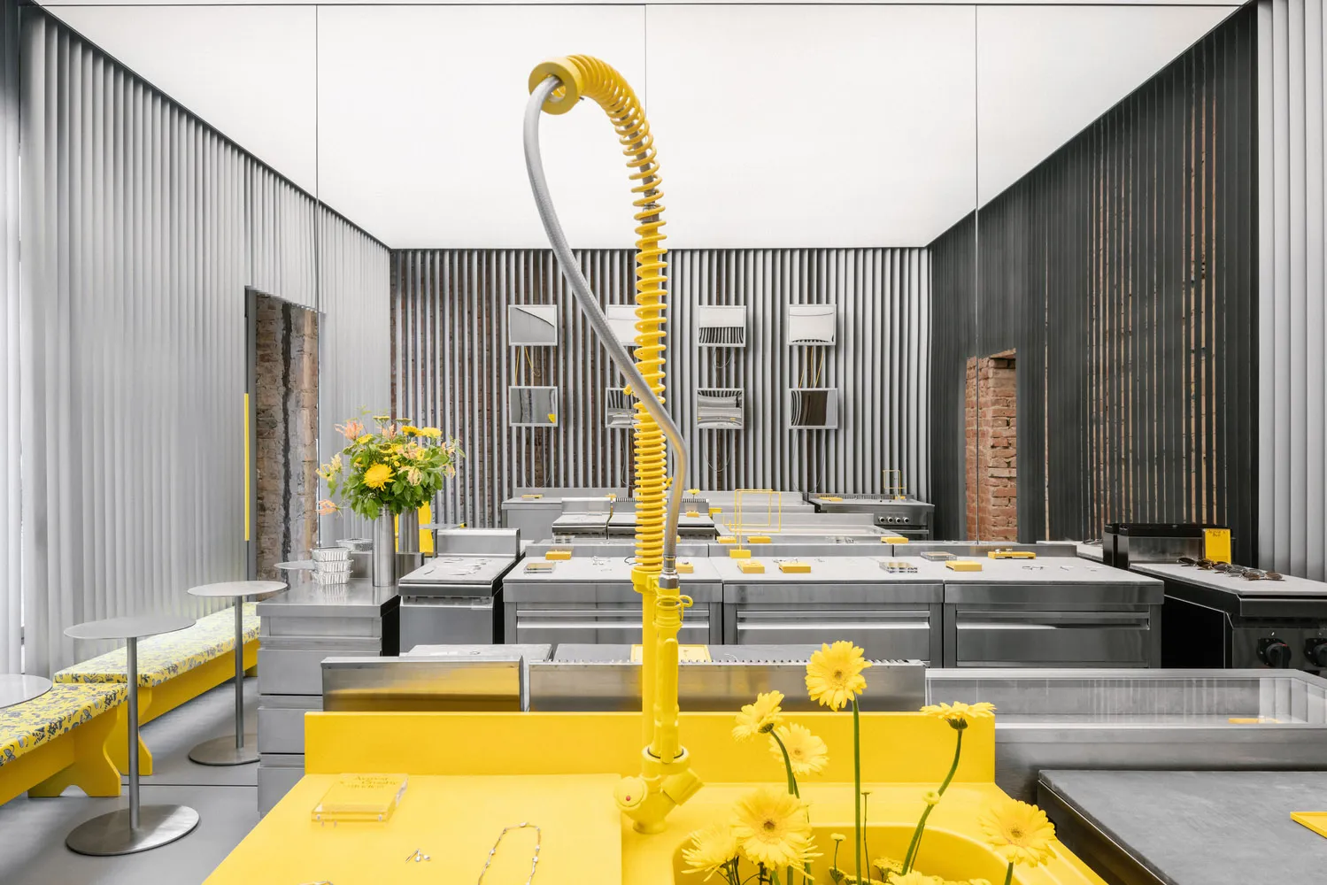 A modern kitchen with yellow tiles, stainless steel appliances, and a white countertop.