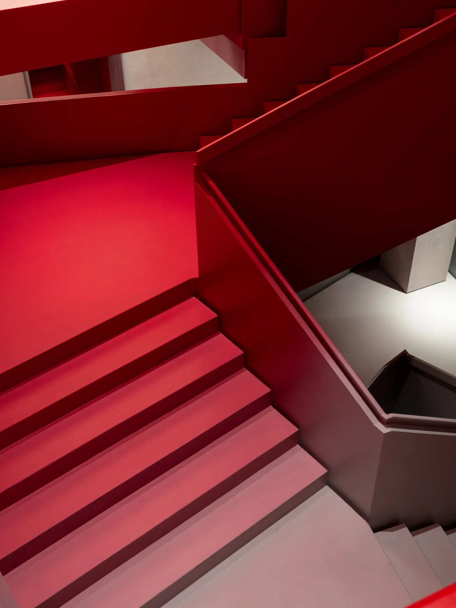 Staircase with red walls and steps, modern design aesthetic.