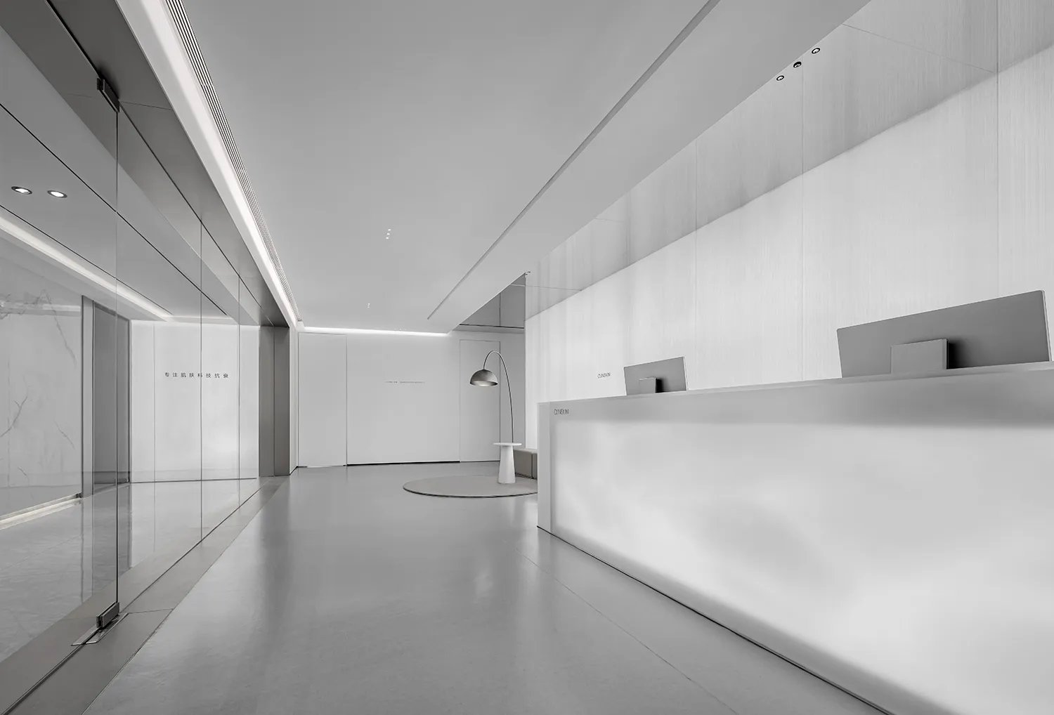 Modern minimalist office lobby with concrete flooring and white walls.