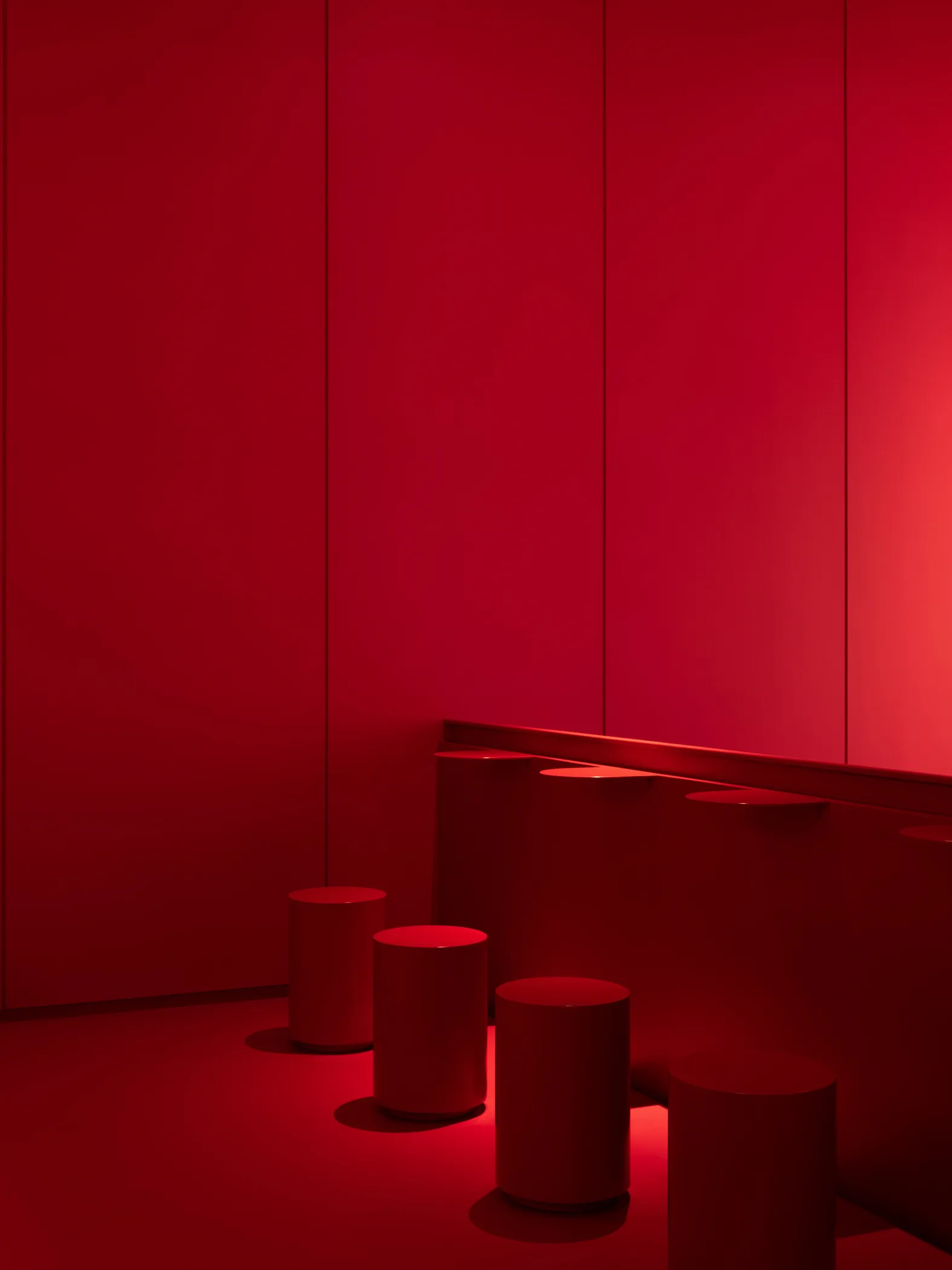 Minimalist room with metallic stools and red walls