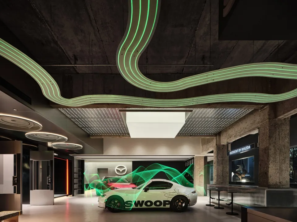 Modern automotive dealership with concrete walls, green neon lights, and a white car with green light effects.