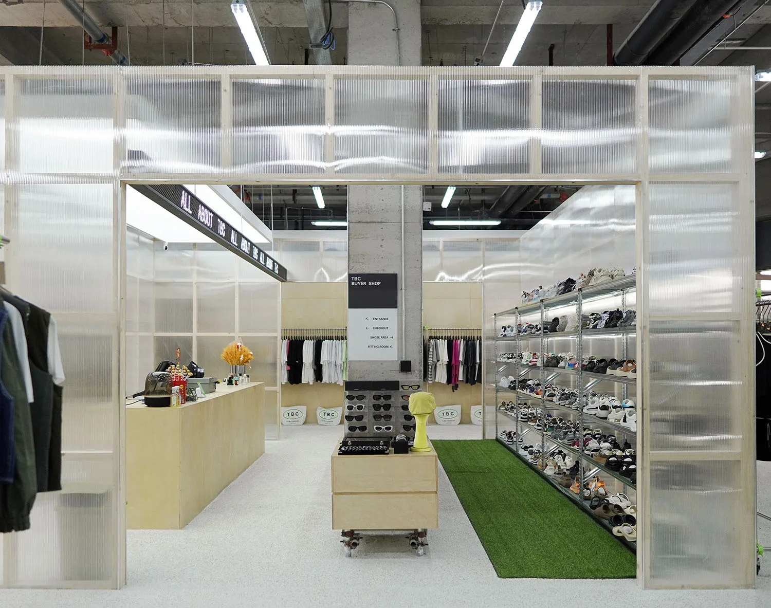 Modern retail space with glass walls and shelves displaying shoes.