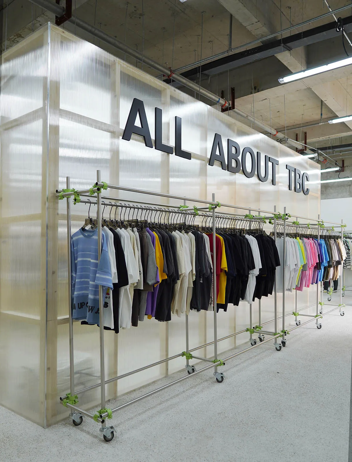 現代工業風格的服裝零售展示,展示架上陳列著各色襯衫。