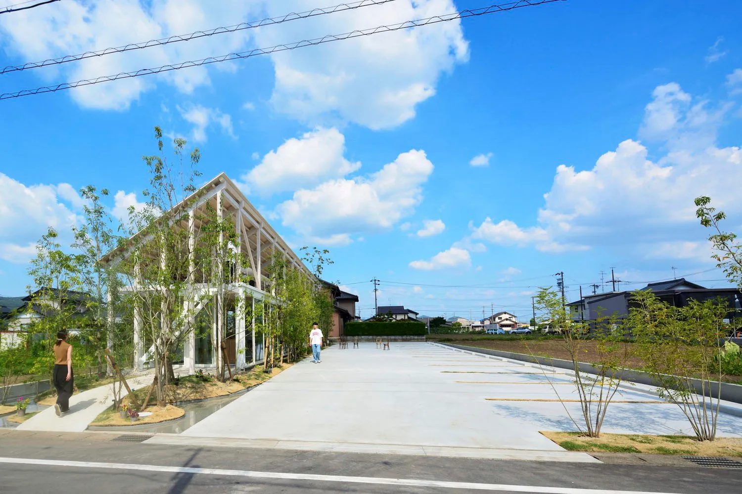 The exterior view of a modern residential building with a concrete facade and a spacious courtyard.