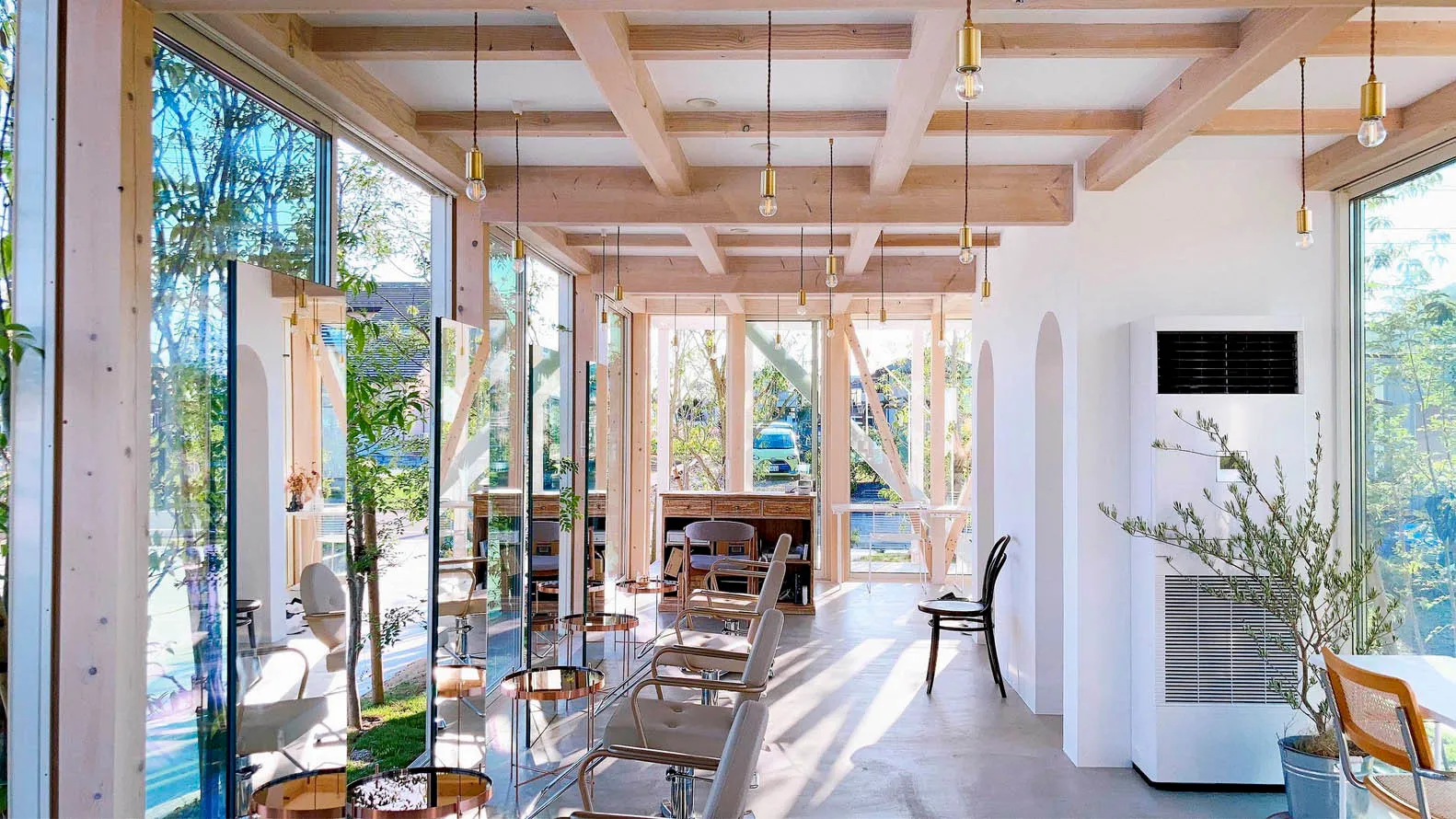 A modern coffee shop featuring glass walls and white walls.