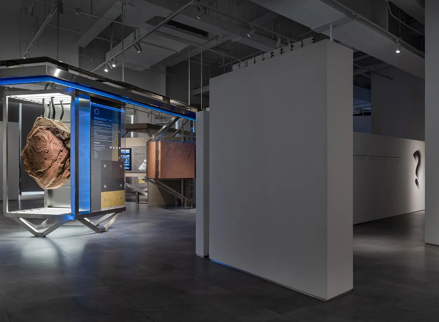 Modern exhibition display with architectural elements and a rock sample.