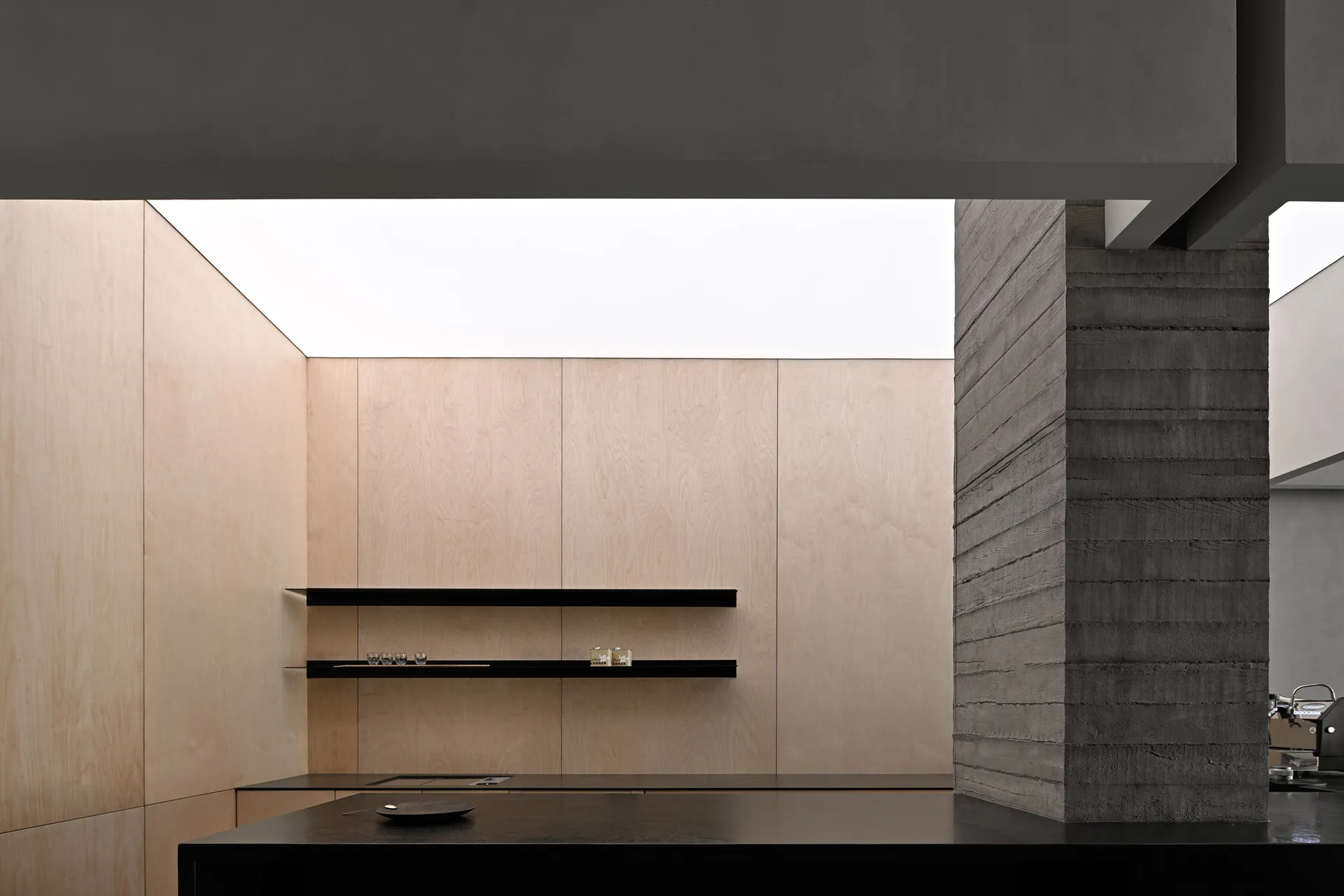 Modern kitchen with minimalist design, featuring wood and concrete materials.
