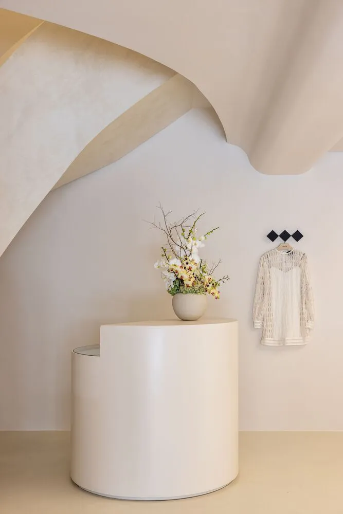 A minimalist modern space with white cylindrical objects and floral arrangement.