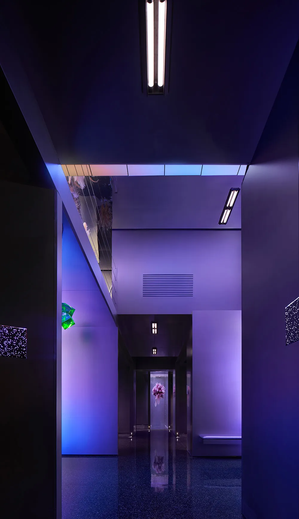 A modern, minimalist hallway with illuminated lighting fixtures.