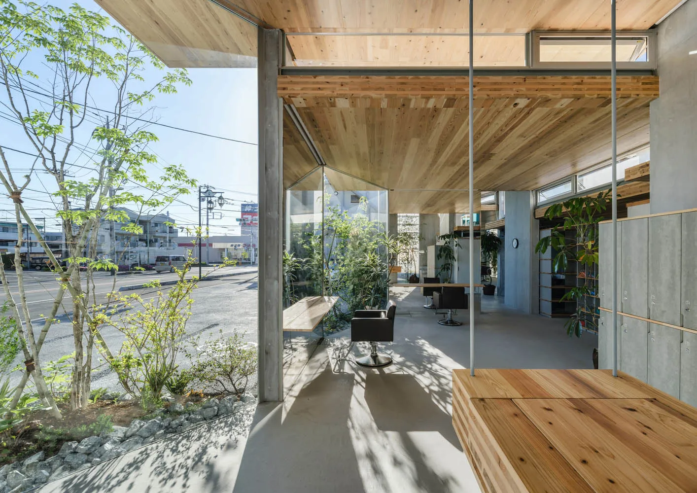 現代室內空間，展現木質元素、混凝土地板與大型玻璃牆。