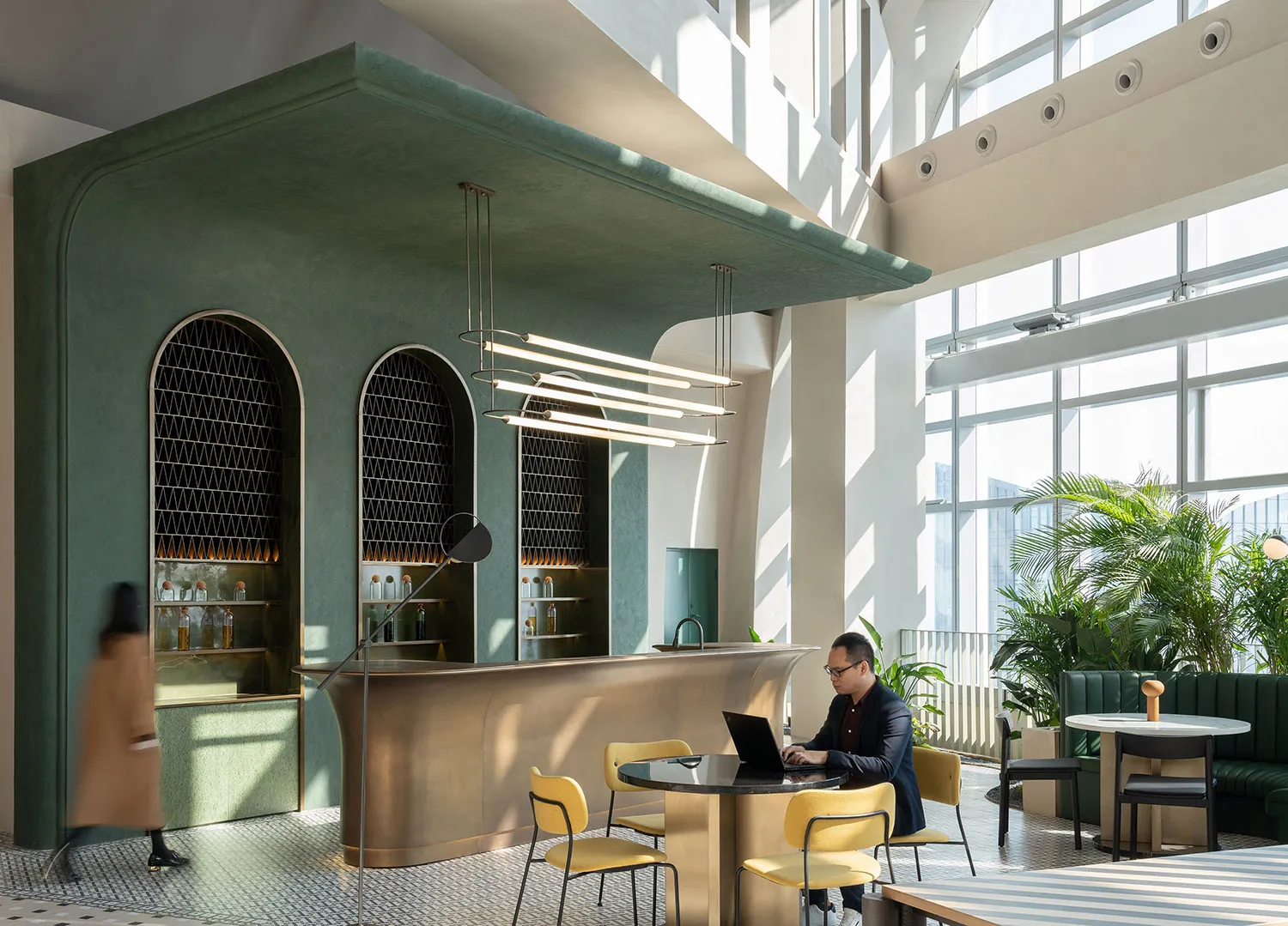 A modern cafe with concrete walls, brass accents, and large windows allowing natural light to fill the space.