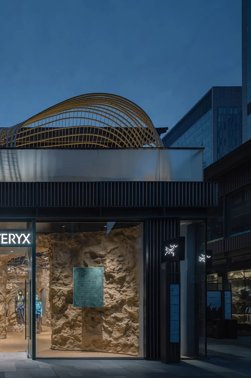 現代零售店面,玻璃牆面搭配混凝土質感,展示 Arc'teryx 品牌標誌。